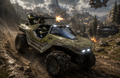 A futuristic off-road military vehicle with a mounted gun turret drives along a rocky mountain path in a dramatic sci-fi battle scene. Soldiers are visible inside the vehicle, with explosions, mountains, trees, and spacecraft in the background.
